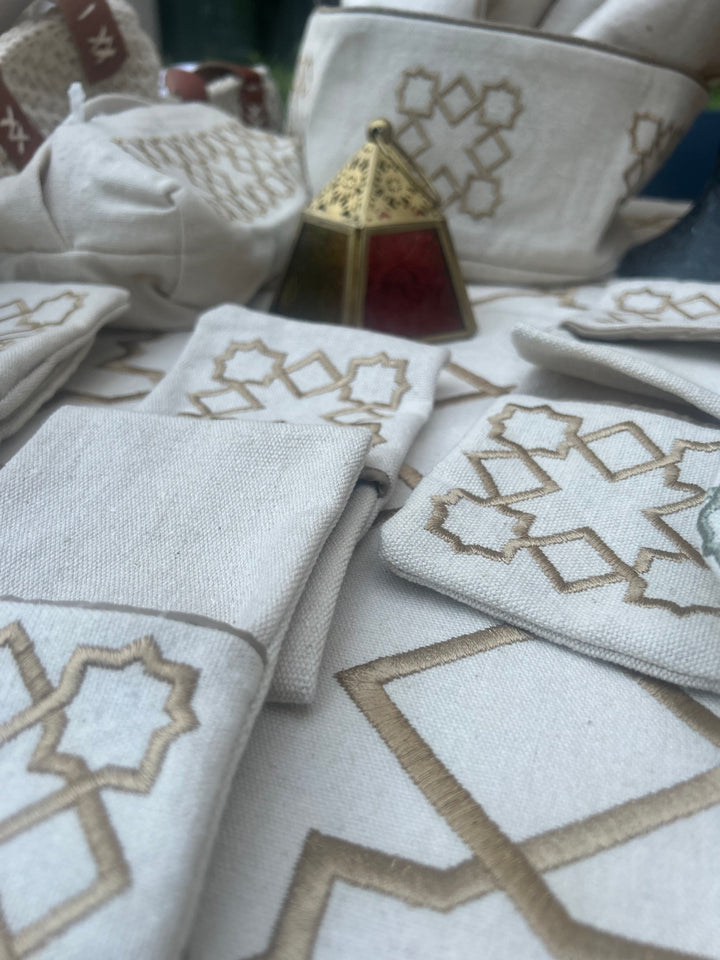 The Arabesque Table Set - 15 Piece Bronze Embroidered set from Raw Cotton placed in a handmade basket with leather handles. 