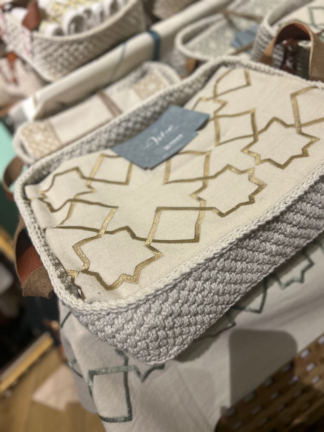 The Arabesque Table Set - 15 Piece Bronze Embroidered set from Raw Cotton placed in a handmade basket with leather handles. This picture shows the handmade basket that the set comes in with the leather handles.