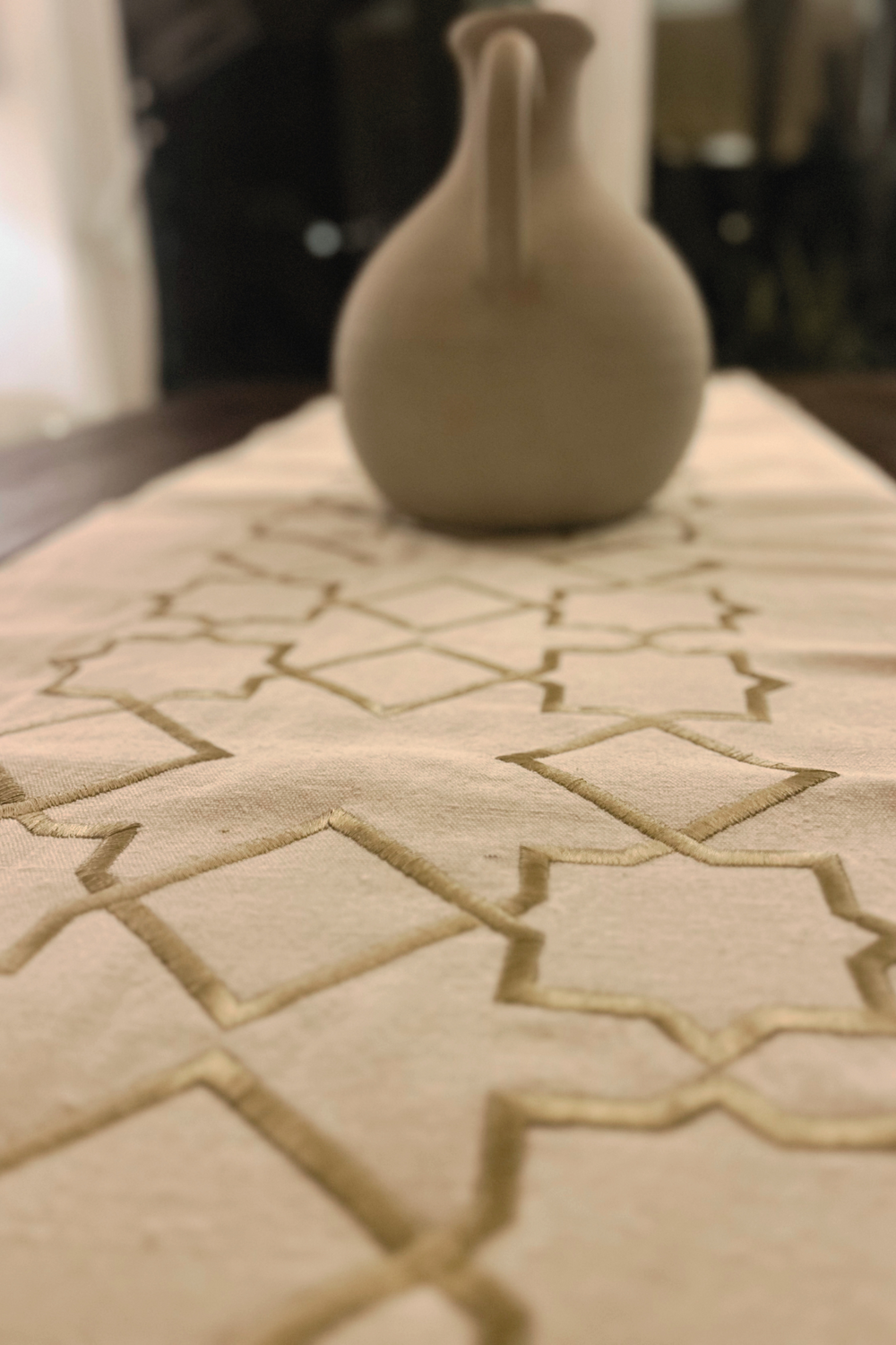 The Arabesque Table Set - 15 Piece Bronze Embroidered set from Raw Cotton placed in a handmade basket with leather handles. This picture shows the runner.
